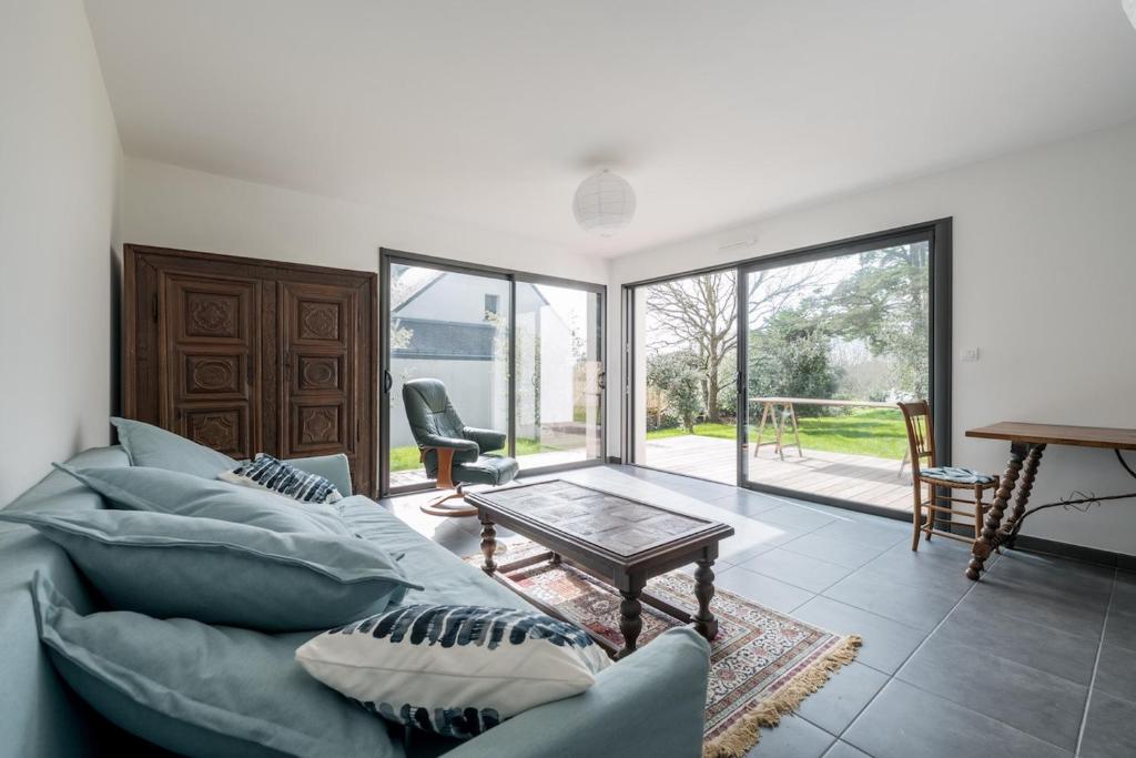 a living room with a couch and a table at Une belle maison ouverte sur le jardin, près de la mer in Piriac-sur-Mer