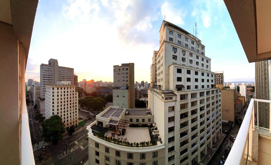 Blick auf ein großes weißes Gebäude in einer Stadt in der Unterkunft Apartamento com WiFi próximo ao metrô Luz in São Paulo