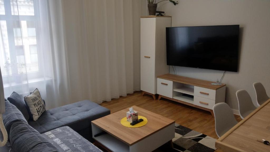 salon z kanapą i telewizorem z płaskim ekranem w obiekcie RYNECZEK w mieście Przemyśl