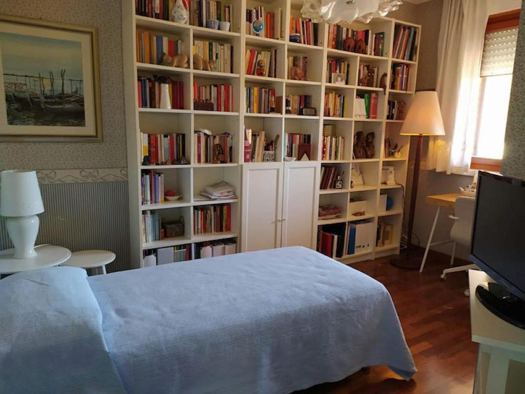 una camera da letto con una libreria piena di libri di Fior di Loto ad Ancona