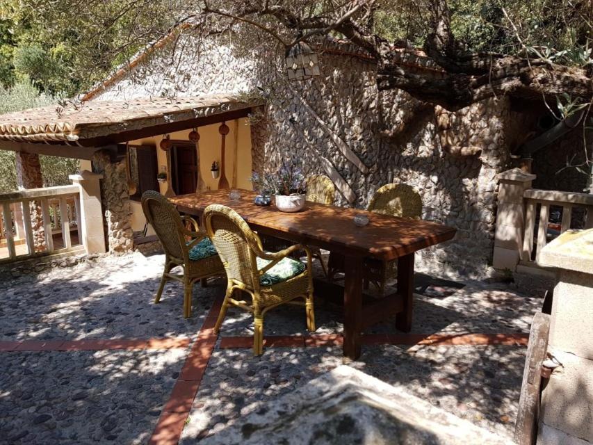 a wooden table and chairs in front of a house at YourHouse Cas Sito in Cala Tuent