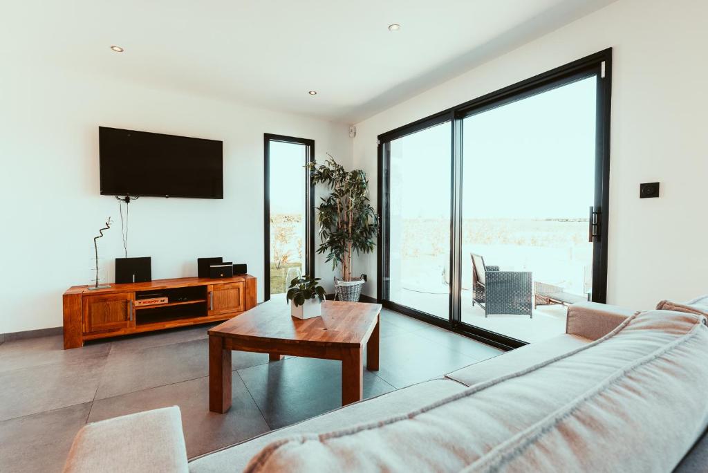 a living room with a couch and a tv at Le Paradis du petit Rupembert in Wimille