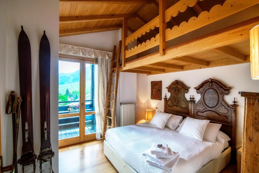 1 dormitorio con cama grande y ventana grande en Charming Mountain Penthouse, en Aprica