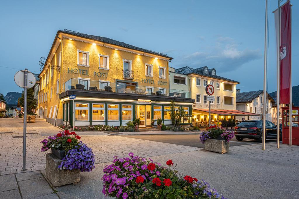 ein gelbes Gebäude mit Blumen davor in der Unterkunft Posthotel Radstadt in Radstadt