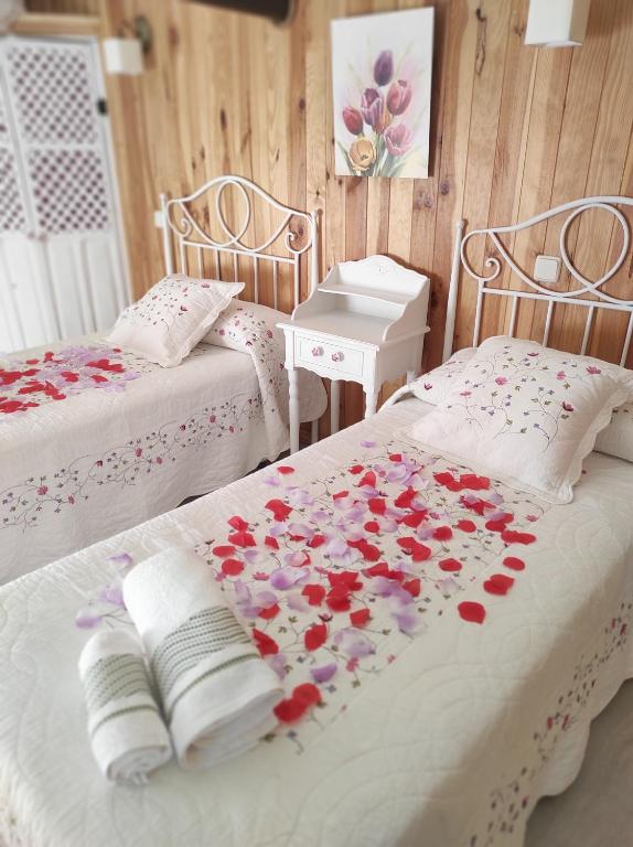 um quarto com duas camas com flores em La Casita, Apartamento Completo em Los Navalucillos