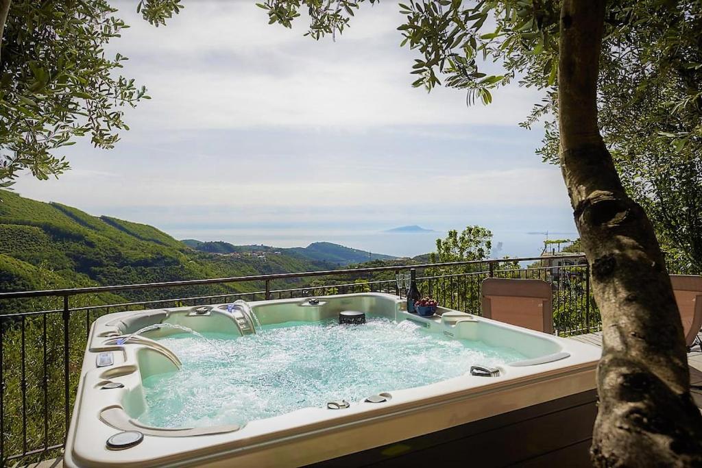 a hot tub on a balcony with a tree at Angolo di Paradiso Sorrento Coast in Moiano