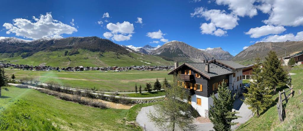 a house on a hill with mountains in the background at Bait Panorama in Livigno
