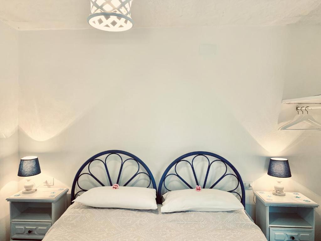 a bedroom with two beds and two night stands at Appartamento Vasiliki in Porto San Paolo