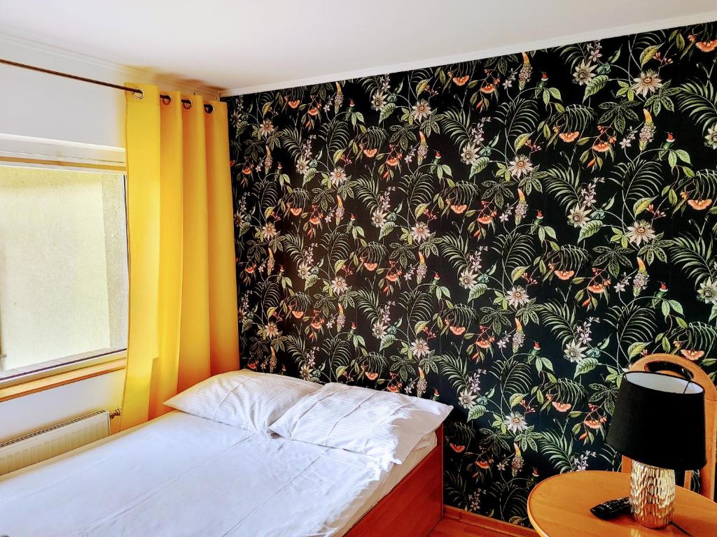 a bedroom with a bed with a floral wallpaper at Pierwsze Piętro Restauracja&Noclegi in Lesko
