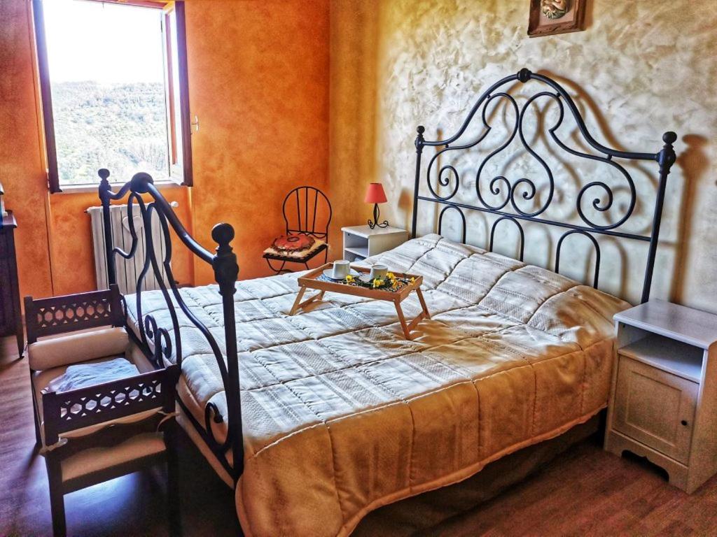 a bedroom with a large bed and a window at B&B Santa Vittoria in Monteleone Sabino