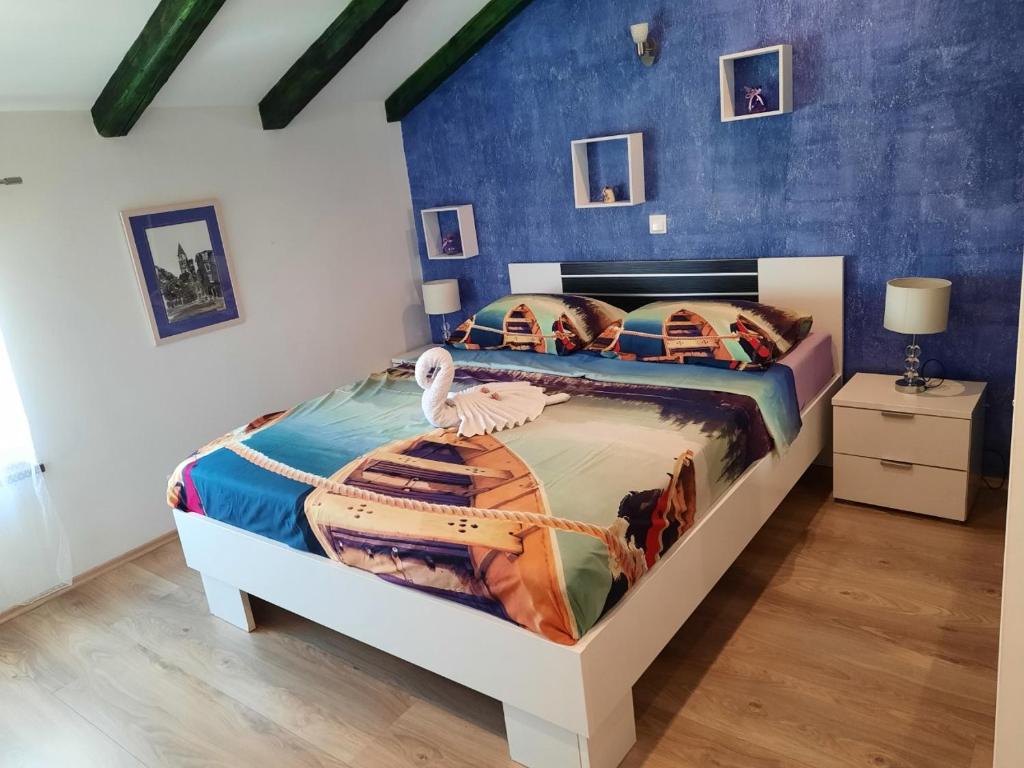 1 dormitorio con 1 cama y suelo de madera en Apartments Marica, en Zadar