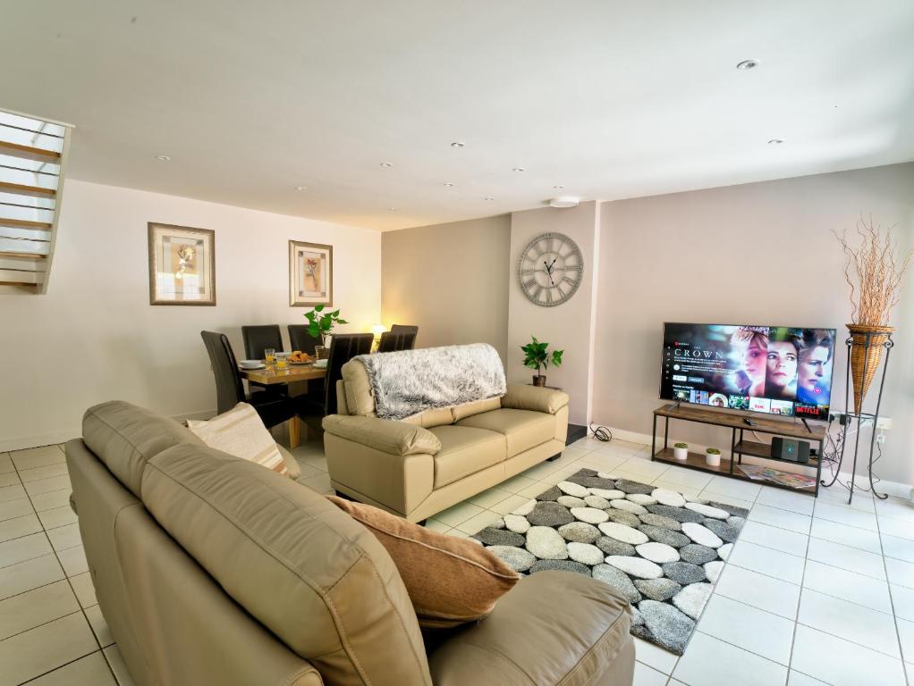 een woonkamer met een bank en een tv bij School Path Ironbridge Home with Rear Terrace in Ironbridge