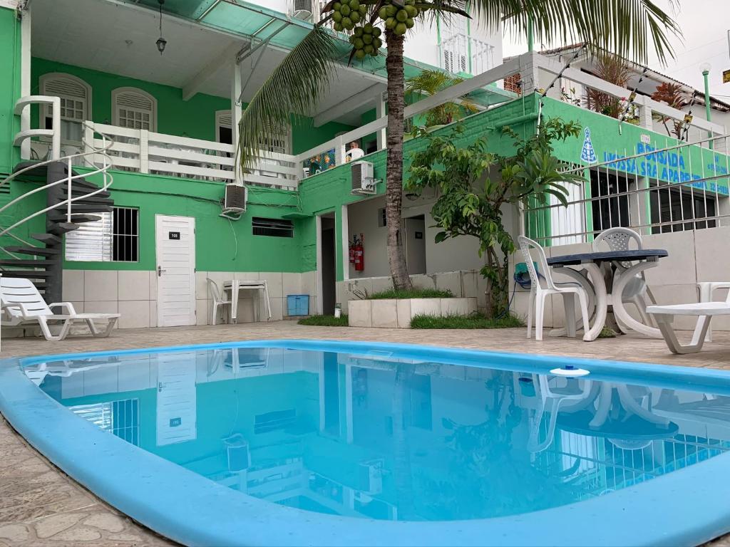 una piscina frente a un hotel con un edificio verde en Pousada Nossa Natal, en Natal
