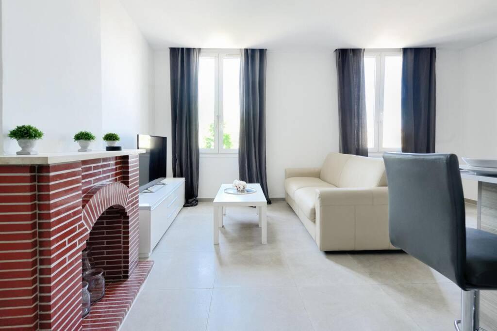 - un salon avec un canapé et une cheminée en briques dans l'établissement LA CIOTAT - Magnifique Appartement climatisé sur le Port, à La Ciotat