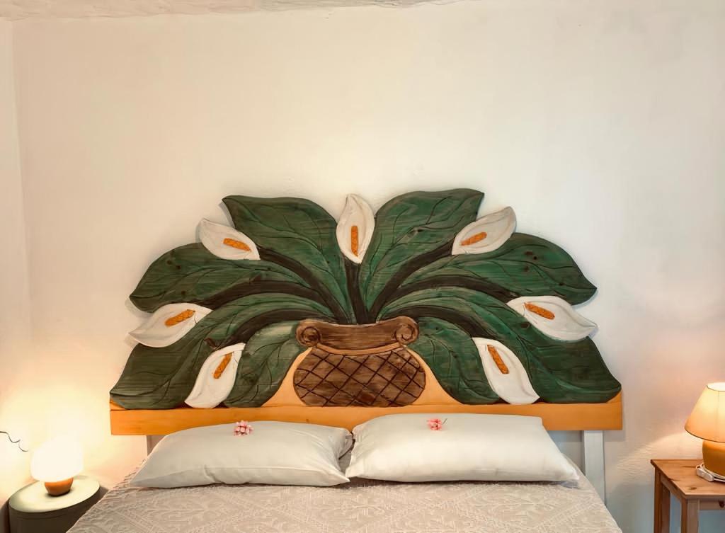 オルビアにあるPinelopi Roomのベッド上壁の木絵