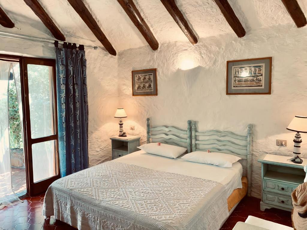 Costa Dorata的住宿－Eleni Room，一间卧室配有一张带两张桌子和一扇窗户的床。