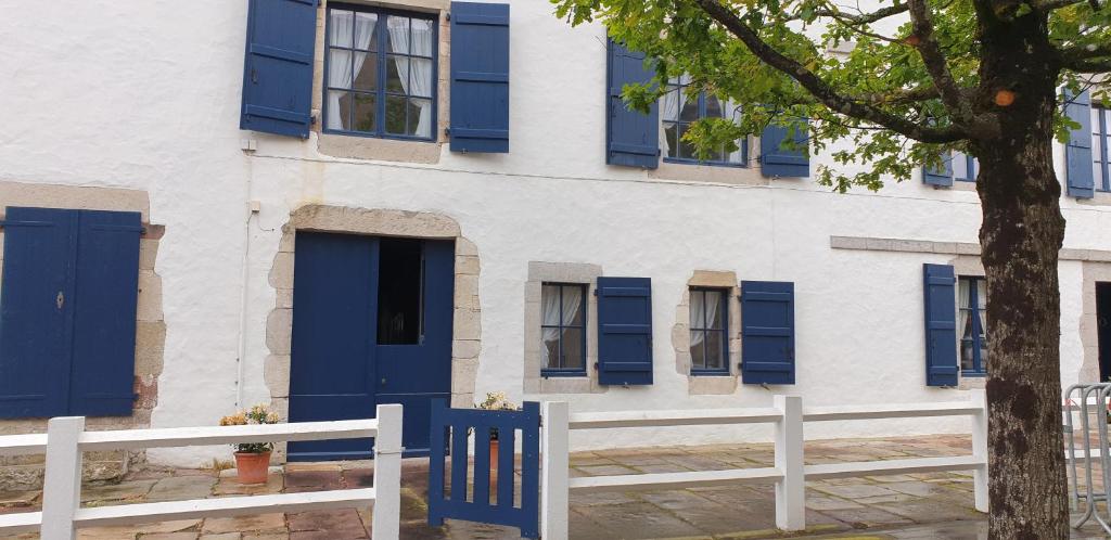 a building with blue doors and a white fence at Ugarte in Urrugne