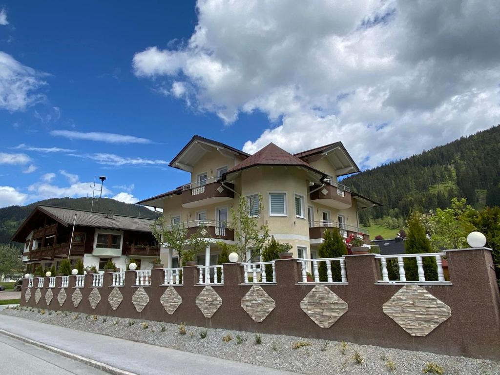 a house behind a fence on the side of a road at Haus Senel in Eben im Pongau