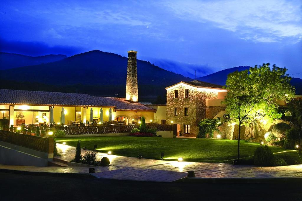 una casa con una montaña en el fondo por la noche en La Masia de Rendé Masdéu, en Espluga de Francolí