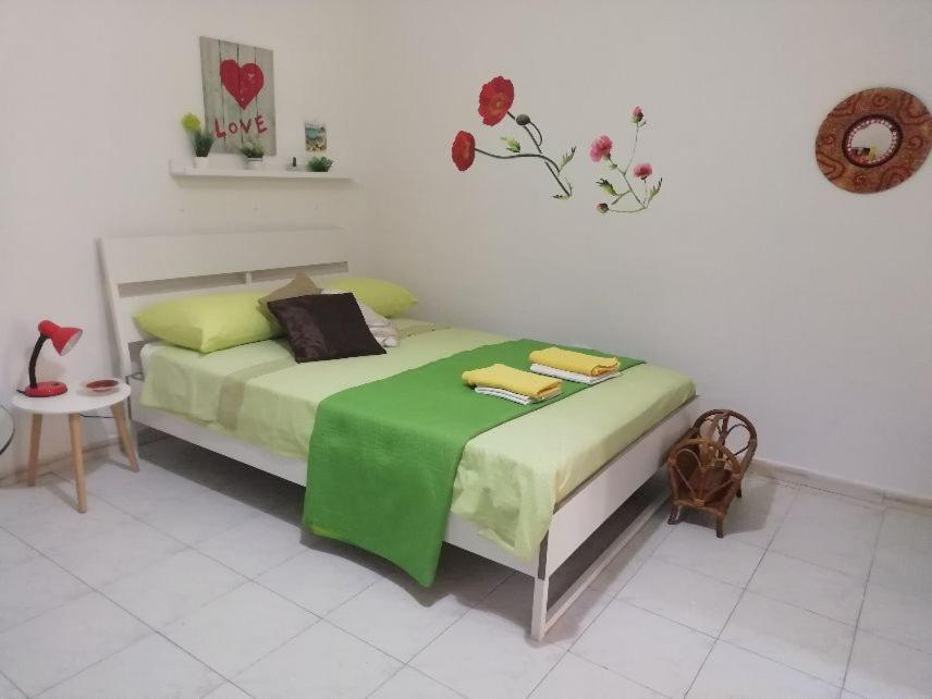 - une chambre avec un lit doté d'une couverture verte dans l'établissement otto di denari, à Naples