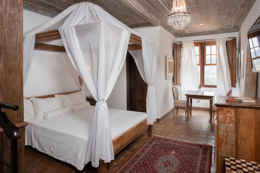 a bedroom with a bed with a canopy at Pouso da Torre in Tiradentes