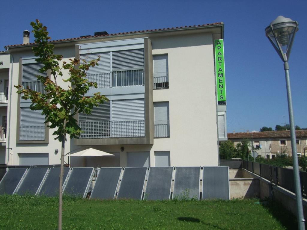 un edificio blanco con una luz de la calle delante de él en Apartaments Verd Natura, en Olot