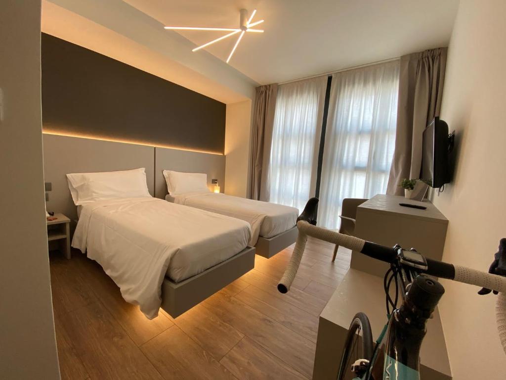 a hotel room with two beds and a television at Fly Bike Hotel in Trento