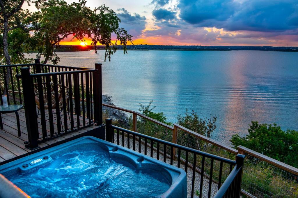 uma banheira de hidromassagem num deque com vista para a água em Happy Owl Lakehouse em Canyon Lake