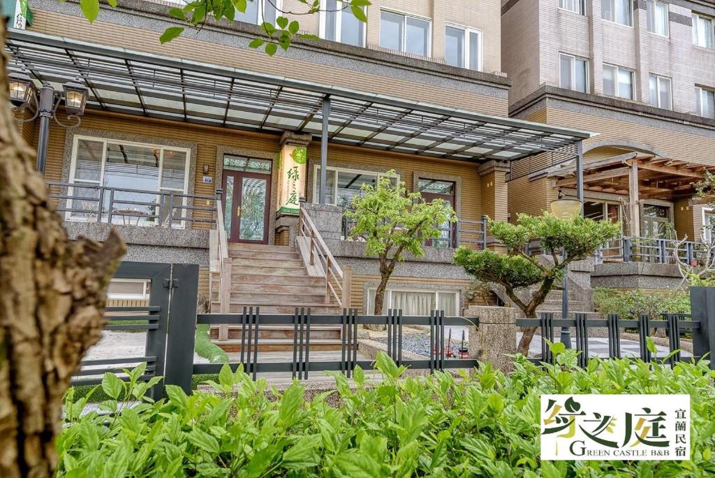 a house with a fence in front of it at 宜蘭綠之庭民宿 in Luodong