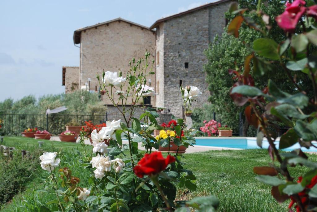 un jardín con flores frente a un edificio en Il Castello Di Perchia, en Crocemaroggia
