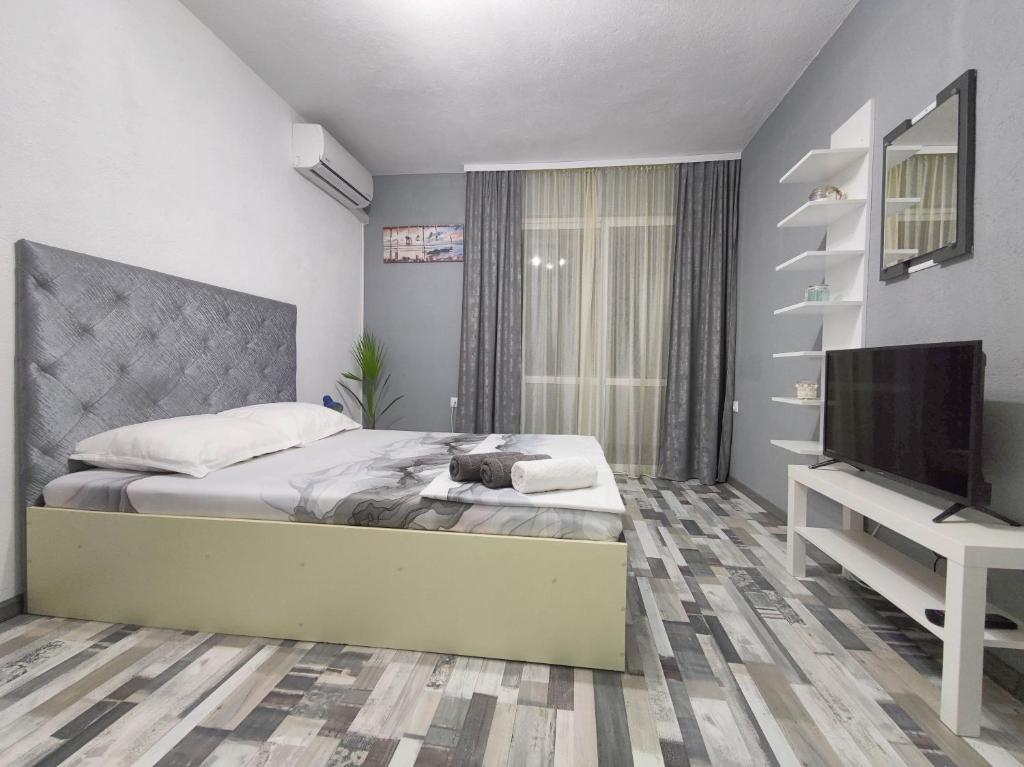 - une chambre avec un lit et une télévision à écran plat dans l'établissement Къща за гости Атмосфера, à Tsarévo