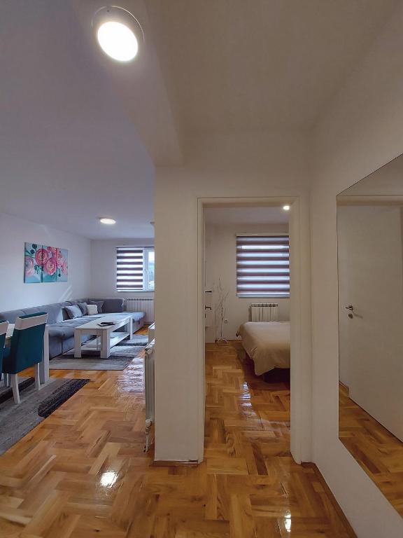 ein Schlafzimmer mit einem Bett und ein Wohnzimmer in der Unterkunft Apartman Victoria in Lukavica