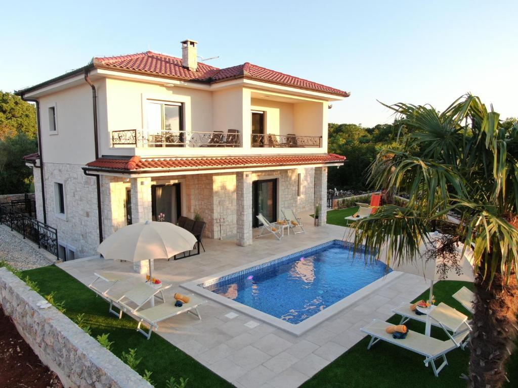 eine Villa mit einem Pool vor einem Haus in der Unterkunft Luxury Villa Sara in Malinska in Sveti Ivan