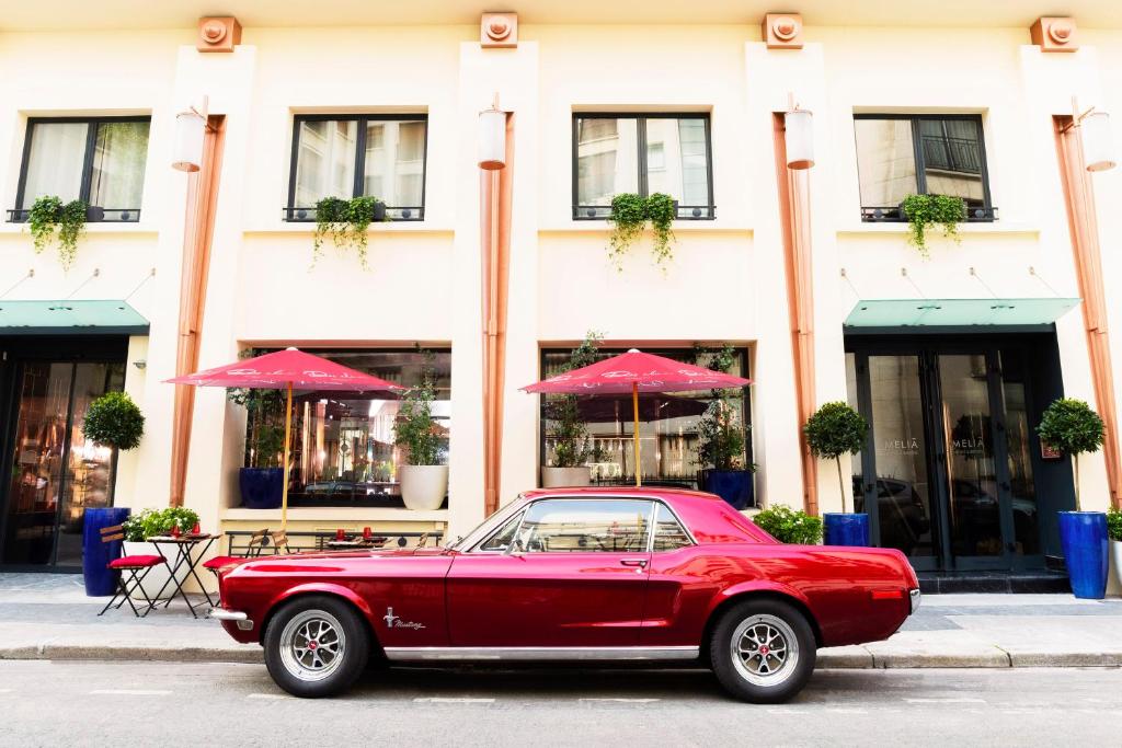 a red car parked in front of a building at Villa Marquis Member of Meliá Collection in Paris
