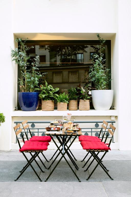 a table and two chairs with red cushions on a patio at Villa Marquis Member of Meliá Collection in Paris