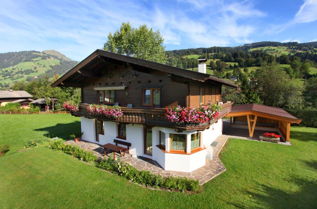 ein kleines Haus mit Blumen im Hof in der Unterkunft Haus Hirzinger in Brixen im Thale