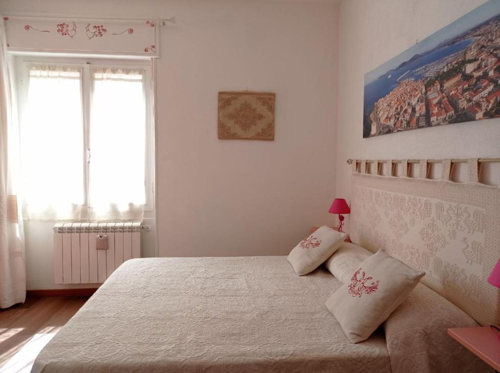 1 dormitorio con 1 cama grande y 2 almohadas en La Pervinca en Alghero