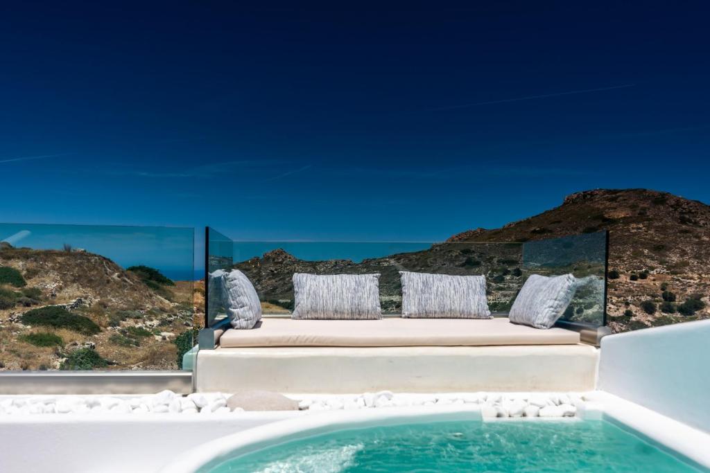 a villa with a swimming pool and a view of the ocean at Geomilos Deluxe Rooms in Triovasálos