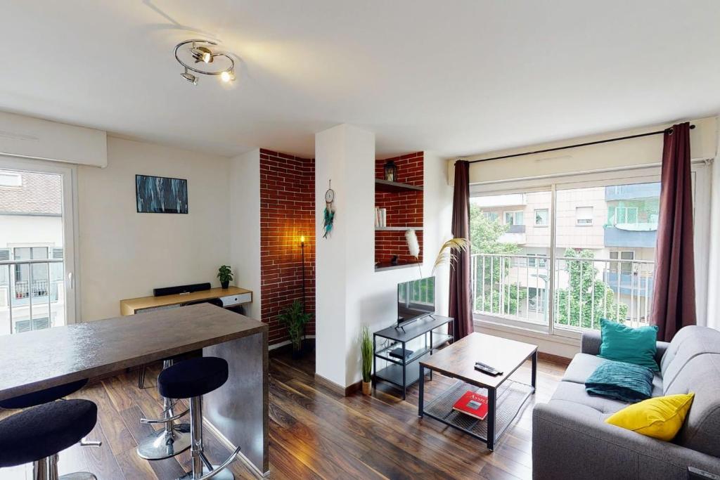 een woonkamer met een bank en een tafel bij Le Berthollet 9 - Renovated apartment 1 bedroom 2 steps - Annecy center in Annecy