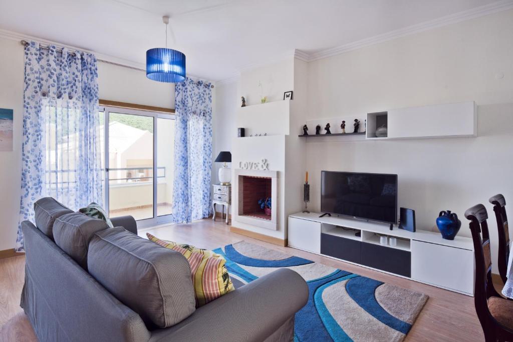 a living room with a couch and a television at BmyGuest - Sesimbra Sea View Villa in Castelo