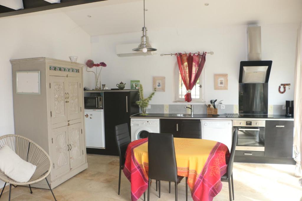 a kitchen with a table with a table cloth on it at Un petit coin de Paradis in Mazan