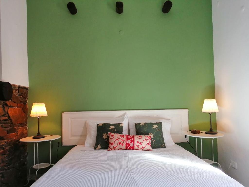 um quarto com uma cama com uma parede verde em Casa Monreal em Reguengos de Monsaraz