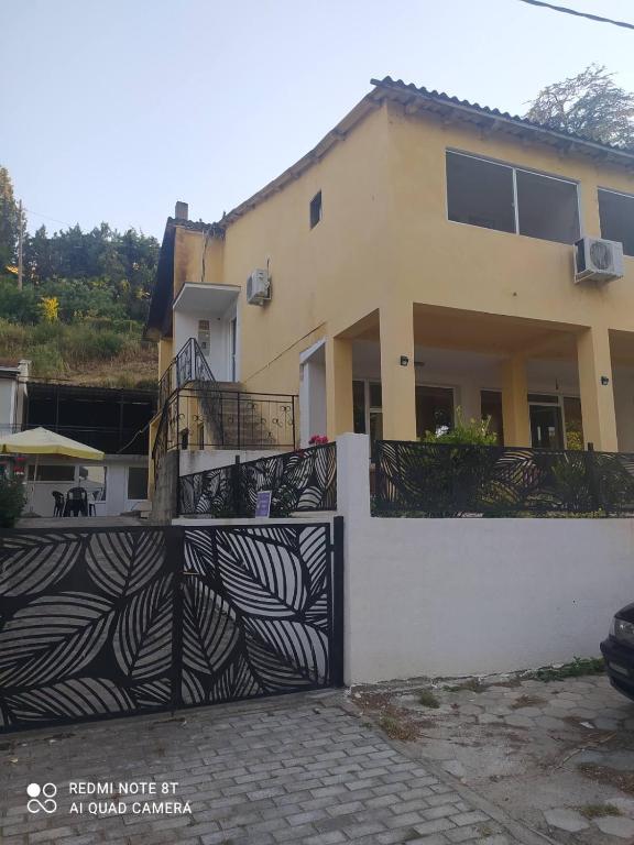 a house with a black and white fence at Apartment Chukov in Star Dojran