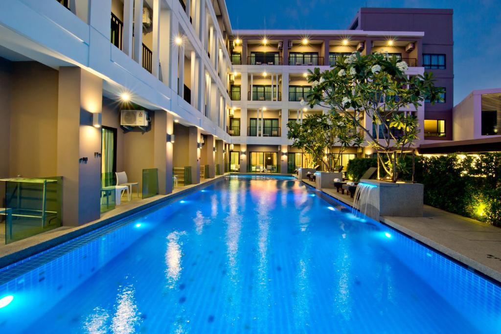 una piscina frente a un edificio por la noche en Hotel J Residence Pattaya - SHA Extra Plus, en Pattaya central