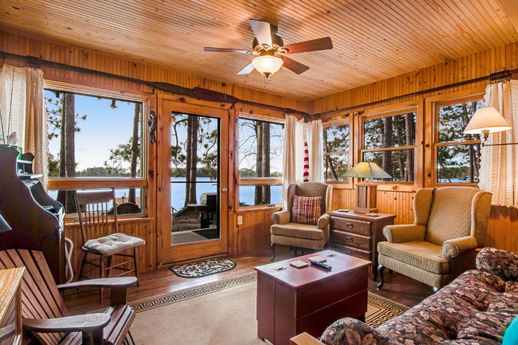 un soggiorno con ventilatore a soffitto e finestre di Bucky's PineIsle Retreat a Three Lakes