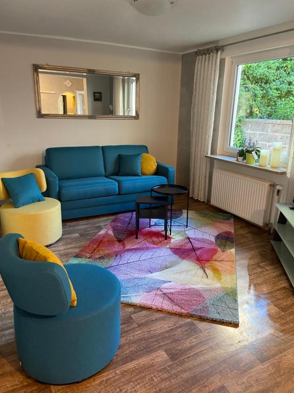 sala de estar con sofá azul y alfombra colorida en Haus Übernachtenswert Cochem Mosel, en Cochem