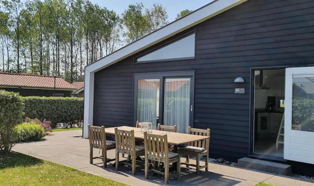 a wooden table and chairs in front of a house at Diek42 in Kattendijke