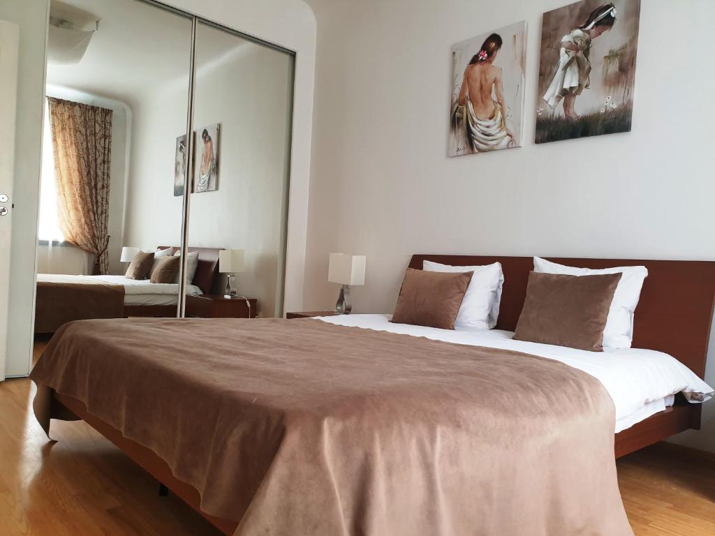 a bedroom with a large bed with a large mirror at City Inn Riga Apartment, Town Hall view with parking in Rīga