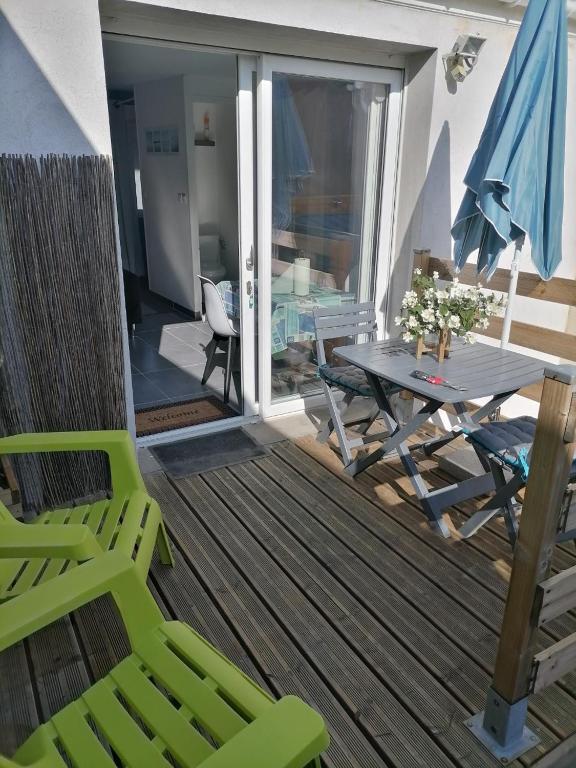 un patio avec une table et des chaises sur une terrasse dans l'établissement Chez Isa, à Saint-Martin-Boulogne