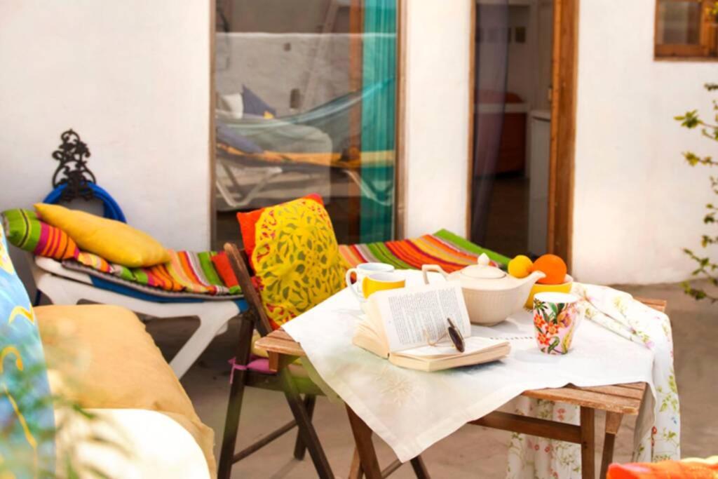 ein Tisch und Stühle mit einem Buch darauf in der Unterkunft Luna - Eco Retreat Finca Artis Tirma in Tarajalejo